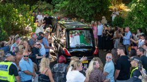 ST5. Bonnie Tyler’s coffin driven home through Mumbles to rapturous applause as thousands line the streets