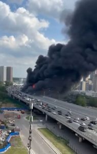 HT9. Dramatic Scenes as Massive Fire Erupts Near Busy US Highway – Thick Black Smoke Engulfs Traffic and City Skyline